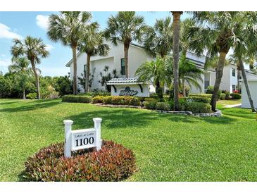 Lakes of Capri building entrance with lush landscaping at 1100 Capri Isles Blvd # 523, Venice, FL 34292