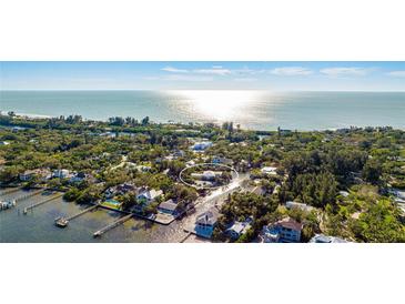 Stunning aerial view of a waterfront home nestled among lush foliage on a canal at 1243 Starboard Ln, Sarasota, FL 34242