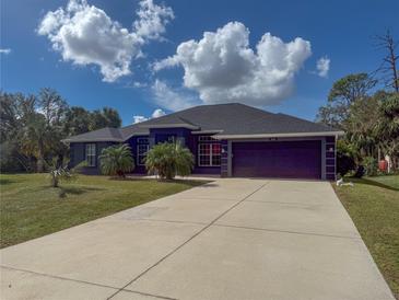 Single-Gathering home with a two-car garage and palm trees at 1661 Atwater Dr, North Port, FL 34288