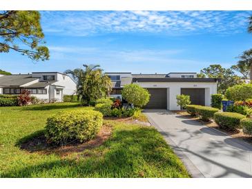 Front view of two-story townhome with attached two-car garage and landscaped yard at 3119 Heatherwood Ln, Sarasota, FL 34235