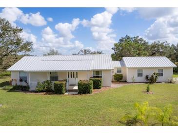 Charming single-story home with a well-maintained lawn, metal roof, and inviting front porch at 38603 Taylor Rd, Myakka City, FL 34251