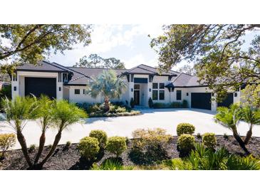 Modern home with a three-car garage and manicured landscaping at 9260 Swaying Branch Rd, Sarasota, FL 34241