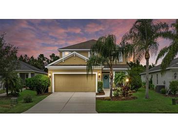 Charming two-story home with a well-manicured front yard, two car garage, and inviting blue front door at 12224 Longview Lake Cir, Bradenton, FL 34211