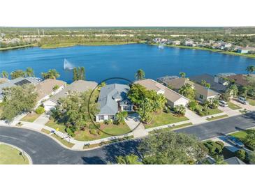 Aerial view of single-story home on lake, showcasing the property and surrounding landscape at 7407 Sea Island Ln, Bradenton, FL 34201