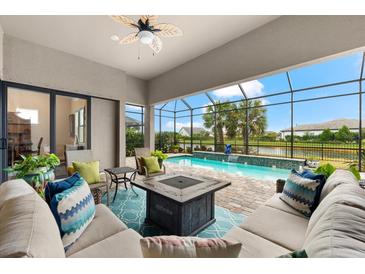 Relaxing screened patio with a pool view, comfortable seating, and a cozy fire pit at 17802 Eastbrook Ter, Lakewood Ranch, FL 34202