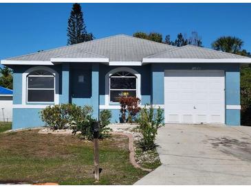 Blue house with a white garage door and landscaping at 1308 72Nd E St, Palmetto, FL 34221