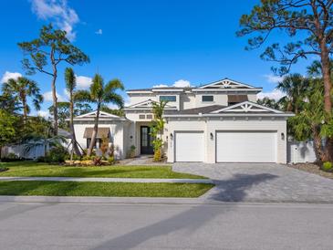 Two-story house with white siding, three-car garage, and landscaped front yard at 1516 S Orange Ave, Sarasota, FL 34239