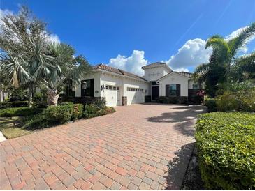 Beautiful single-Gathering home with a three-car garage, brick driveway, and manicured landscaping at 15618 Castle Park Ter, Lakewood Ranch, FL 34202