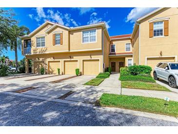 Charming townhomes with a red tile roof, and attached garages on a sunny day at 3619 Parkridge Cir # 11-102, Sarasota, FL 34243