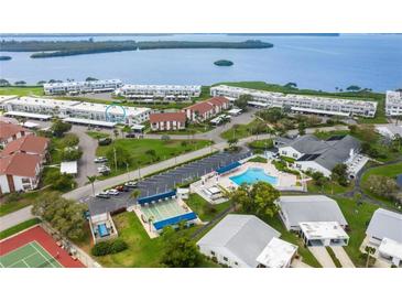 Aerial view of waterfront community with pool, tennis courts, and bay access at 4813 Independence Dr, Bradenton, FL 34210