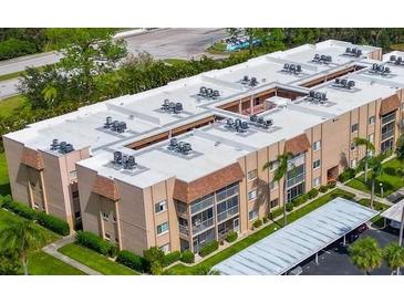 An aerial view of a well-maintained condominium building with lush landscaping and parking at 1540 Glen Oaks E Dr # B336, Sarasota, FL 34232