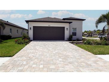 New construction home with attached garage and paver driveway at 16801 Celebration Dr, Port Charlotte, FL 33953