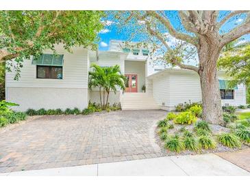 Modern white house with a brick driveway and lush landscaping at 328 Monroe Dr, Sarasota, FL 34236