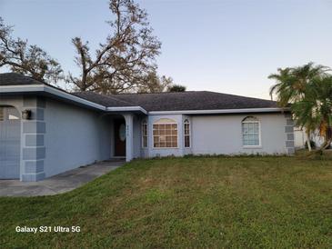 Ranch style home with a well-maintained lawn and neutral exterior at 4016 Bula Ln, North Port, FL 34287