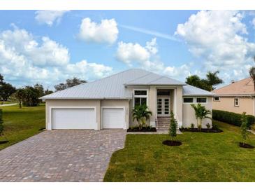 Two-story house with light beige walls, white garage doors, and a paved driveway at 16381 Cape Horn Blvd, Punta Gorda, FL 33955