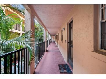 Hallway features a peach-colored corridor with exterior views and a welcome mat, leading to residences at 3700 S Osprey Ave # 214, Sarasota, FL 34239