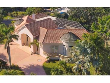Luxury home with tile roof, pool, and circular driveway; located in a lush, tree-lined neighborhood at 5331 Siesta Cove Dr, Sarasota, FL 34242