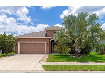 Two-story home with attached garage and palm tree at 7746 108Th Avenue E Cir, Parrish, FL 34219