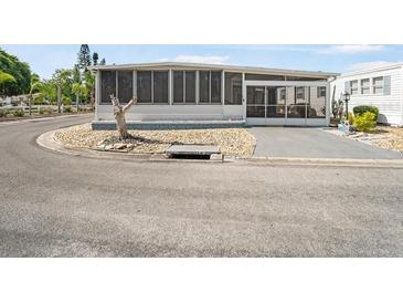 Mobile home with screened porch and gravel driveway at 2107 Palma Sola Blvd # 94, Bradenton, FL 34209