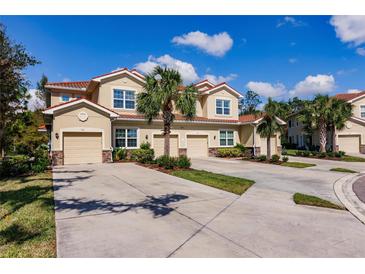 Attractive townhome complex featuring well-manicured lawns, mature palm trees, and tile roofs at 8256 Enclave Way # 101, Sarasota, FL 34243