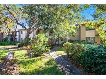 Attractive condo building with lush landscaping and a walkway at 1717 Pelican Cove Rd # 334, Sarasota, FL 34231