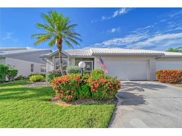 Charming home featuring a lush, landscaped yard and a well-maintained exterior with a palm tree at 5395 Christie Ann Pl # 9, Sarasota, FL 34233