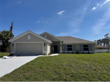 Charming single-story home featuring a two-car garage, well-manicured lawn, and blue shutters at 4744 Badali Rd, North Port, FL 34286