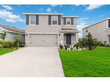 Two-story house with gray siding, two-car garage, and a well-manicured lawn at 5058 Granite Dust Pl, Palmetto, FL 34221