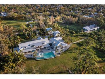 Aerial view of a luxurious farmhouse with pool, expansive lawn, and detached garage at 8413 9Th Nw Ave, Bradenton, FL 34209