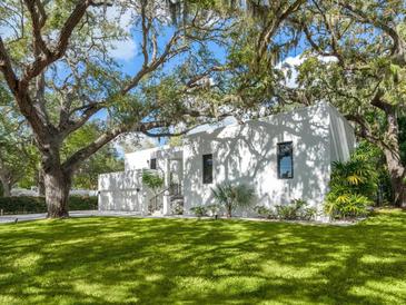 Modern white house with a two-car garage and lush landscaping at 1331 Quail Dr, Sarasota, FL 34231