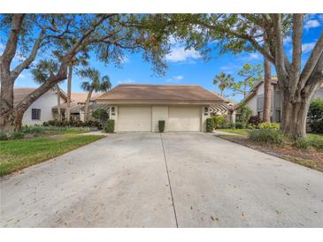 Front view of a two-car garage villa with landscaping at 3375 Sandleheath # 34, Sarasota, FL 34235