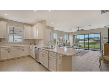Modern kitchen with white cabinets, stainless steel appliances, and breakfast bar at 5431 Taliaferro Ct, Palmetto, FL 34221