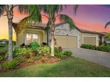 Stunning curb appeal with three-car garage, stone accents, and lush landscaping at 2520 Avolet Ct, Bradenton, FL 34211