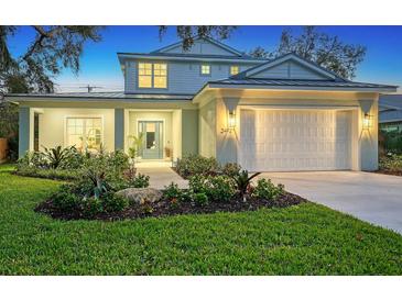Two-story home with a white exterior, landscaping, and a two-car garage at 2492 S Milmar Dr, Sarasota, FL 34237