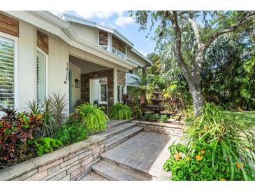 Inviting front entry with stone steps, landscaping, and a water fountain at 1430 Kimlira Ln, Sarasota, FL 34231