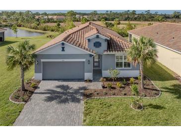 Single-story home with gray exterior, tile roof, and landscaped yard at 225 Daylily Blvd, Nokomis, FL 34275