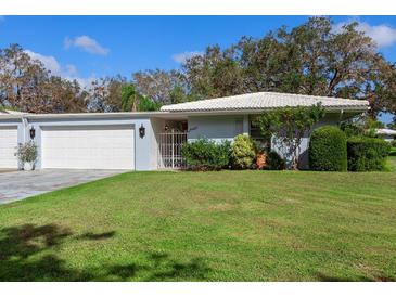 Single-story house with white garage doors and green lawn at 3761 Somerville Dr # 1518, Sarasota, FL 34232