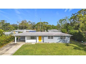 A charming ranch-style home with a yellow door and well-maintained lawn at 2877 Michigan St, Sarasota, FL 34237