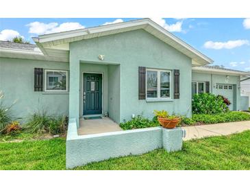 Light teal home with dark shutters, landscaping, and a welcoming front porch at 212 83Rd St, Holmes Beach, FL 34217