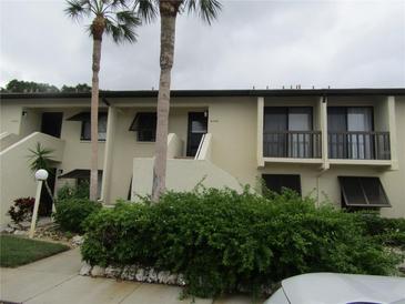Condo building exterior with lush landscaping and parking at 4546 Longwater # 44, Sarasota, FL 34235
