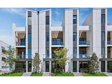Modern three-story townhouses with balconies and landscaped yards at 62 Audubon Pl, Sarasota, FL 34237