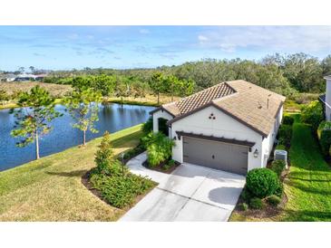 Single-story home with tile roof, lake view, and two-car garage at 12926 True Blue Cir, Bradenton, FL 34211