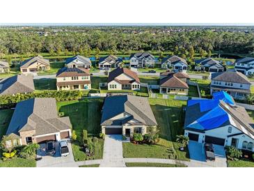 Aerial view of a community with multiple houses, showcasing landscaping and curb appeal at 13051 Utopia Loop, Bradenton, FL 34211