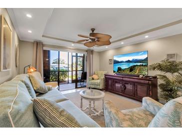 Comfortable living room with plush seating, neutral color palette, and sliding doors to lanai with a ceiling fan at 4119 61St Avenue W Ter # 105, Bradenton, FL 34210