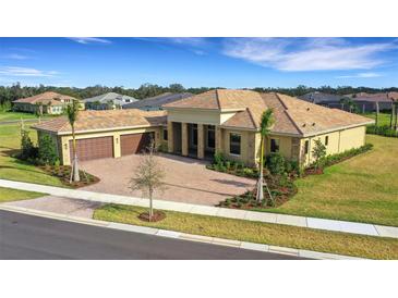 Luxury home with tile roof, three-car garage, and landscaped yard at 4672 Mondrian Ct, Sarasota, FL 34240