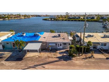 Waterfront home with carport and blue tarp at 19 Seaside Ct, Holmes Beach, FL 34217