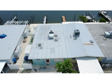 Aerial view of waterfront home with dock access and patio for relaxing and enjoying the coastal breeze at 23 Seaside Ct, Holmes Beach, FL 34217