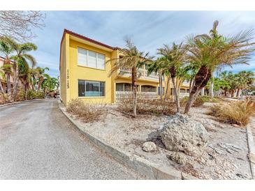 Attractive yellow building with palm trees and a paved driveway at 115 Tyler Dr # 203, Sarasota, FL 34236