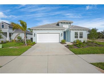 Light blue single-Gathering home with white garage door and landscaping at 10214 Crystal Isle Cir, Sarasota, FL 34241