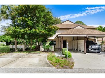 Tan home with a carport, driveway, and mature landscaping, including vibrant green trees at 3415 51St Avenue W Cir # 206, Bradenton, FL 34210